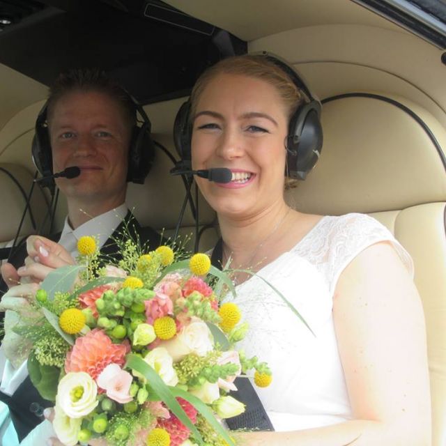 Ein Brautpaar sitzt im Helikopter