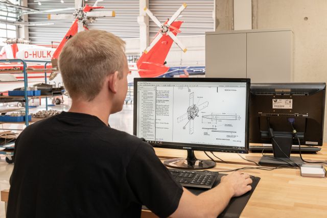 Mann schaut sich technische Zeichnungen am Computer an.